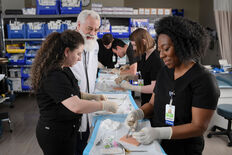 A physician assistant student practices sewing stitches