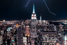 Dramatic view of NY skyline with lightning striking the Empire State Building.