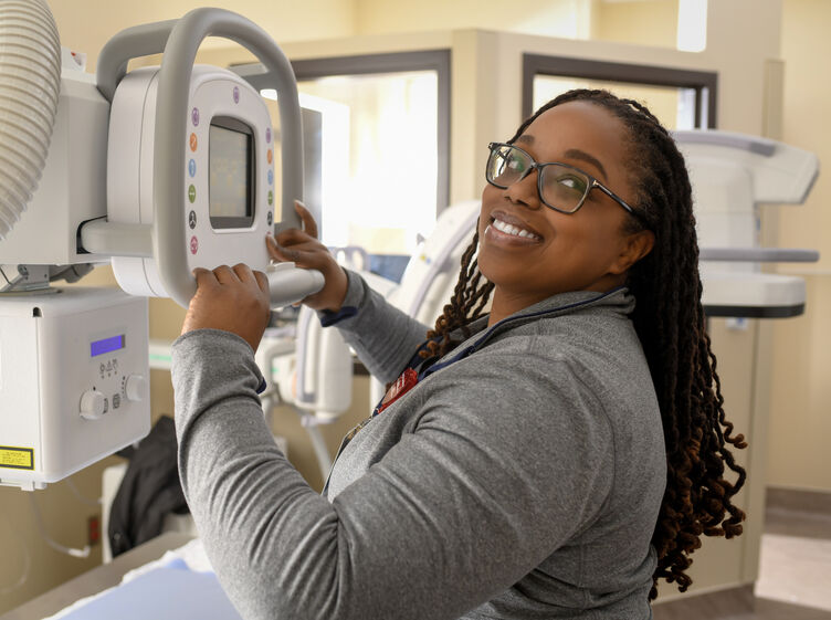 An x-ray imaging technologist operating a machine