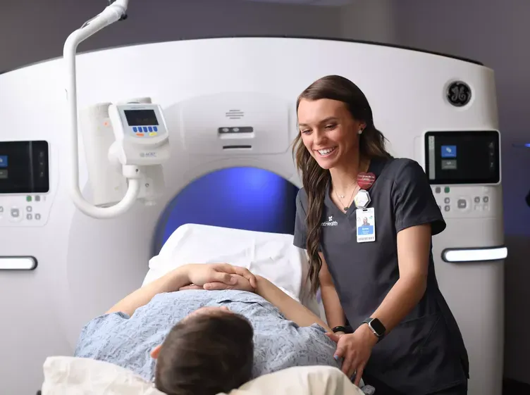 A CT tech smiles at a patient about to be scanned