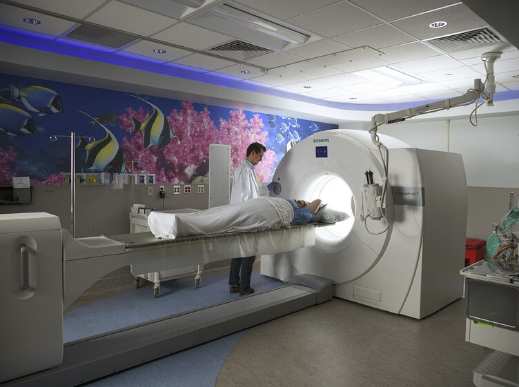 Physician performing PET scan on patient