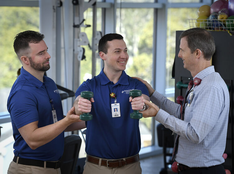 Physical Therapy students and professor using weights