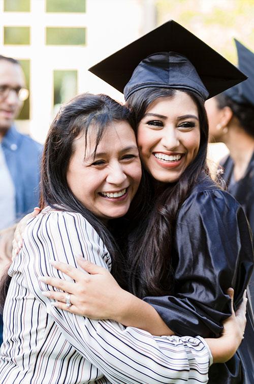 A female graduate hugs her mother