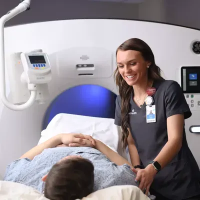 A CT tech smiles at a patient about to be scanned