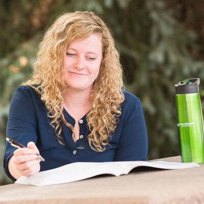A female student studying outdoors at a picnic table
