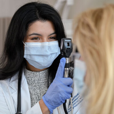 A female PA student in the lab conducting an eye exam on a patient