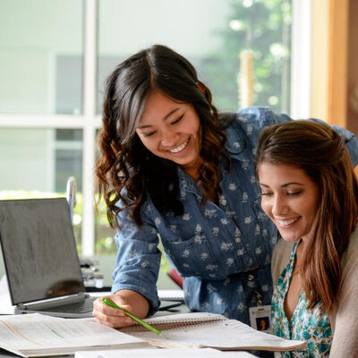 Two female students study together in a classroom