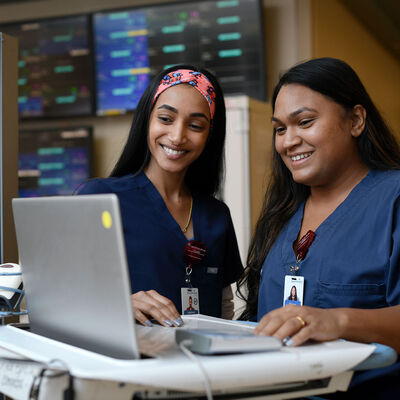 Young nurses viewing a computer on a mobile workstation
