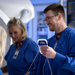 An imaging technologist working with a team in a hospital