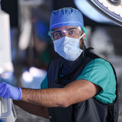 A healthcare worker operating an imaging machine during surgery