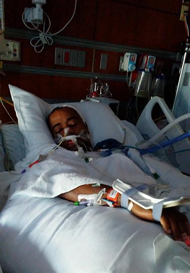 Glexey Caraballo in a bed in the hospital.