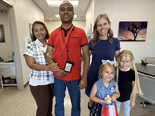 Glexey Caraballo stands with his mother, and Cathy Garrett stands with her daughters. Both Glexey and Cathy performed in STROKESTRA as part of their recovery.