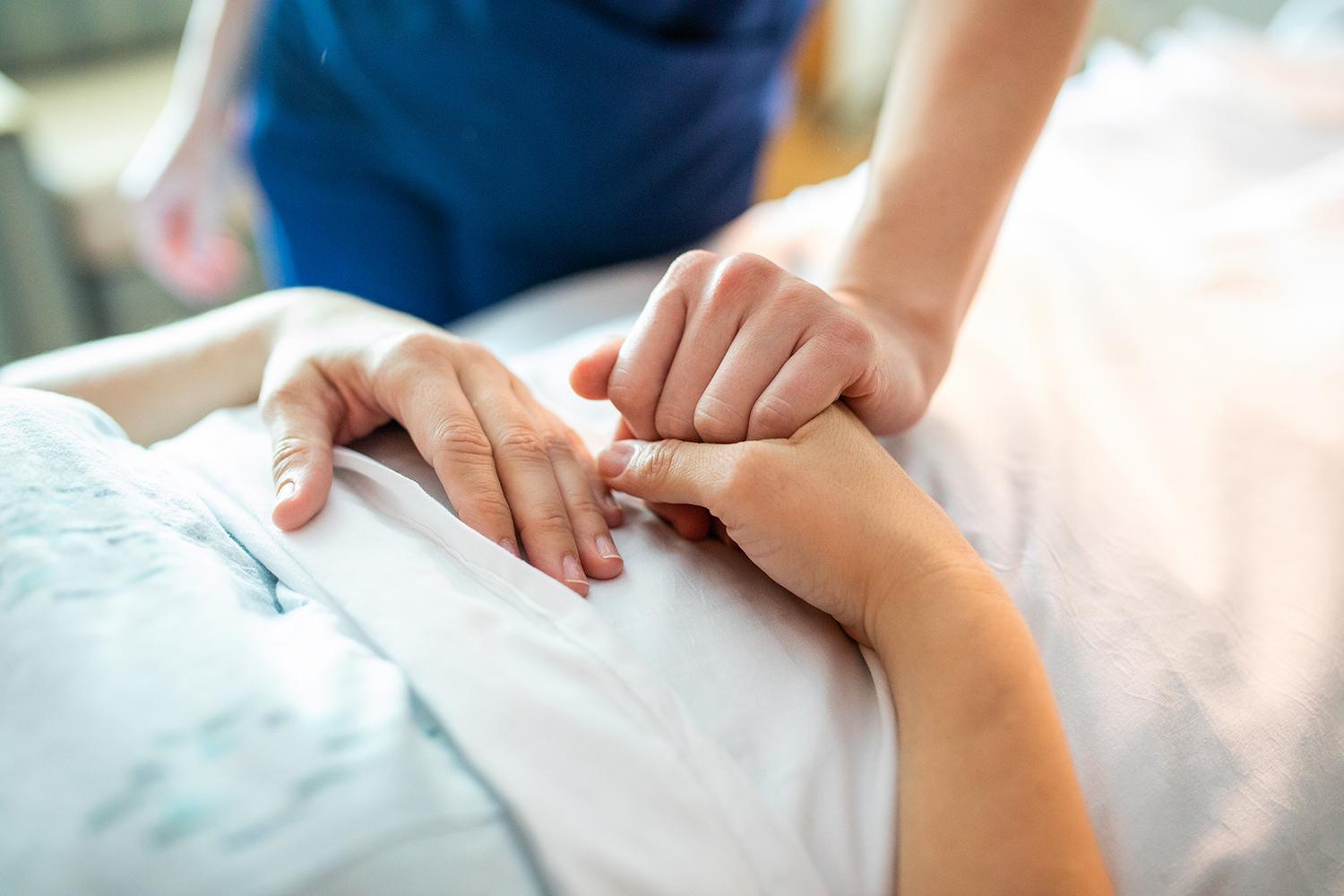 image of praying hands in hospital room