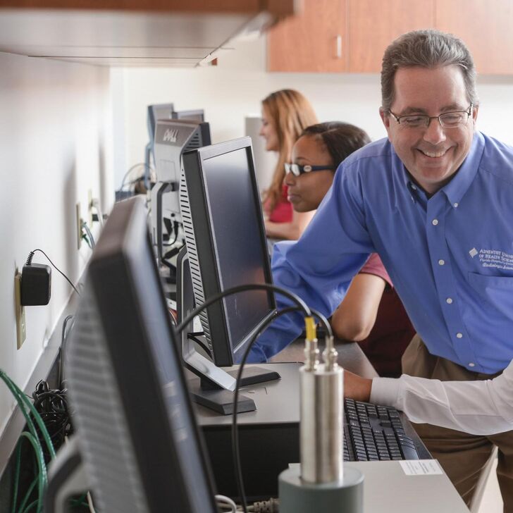Joseph Hawkins with a student using a computer
