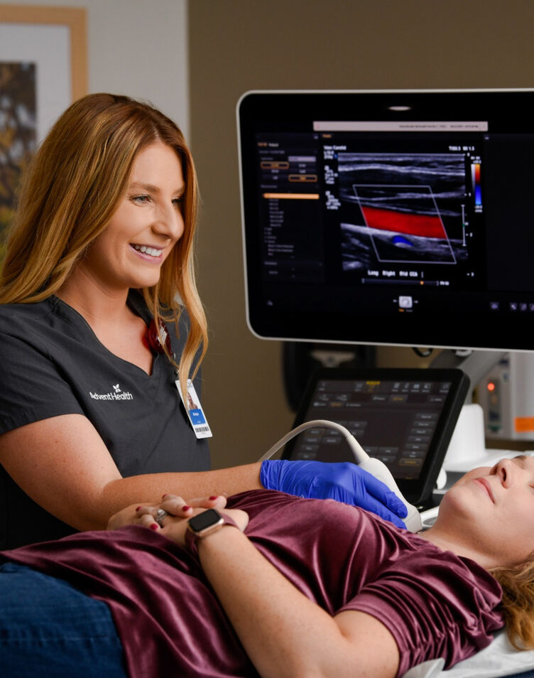 A sonographer scans a patient