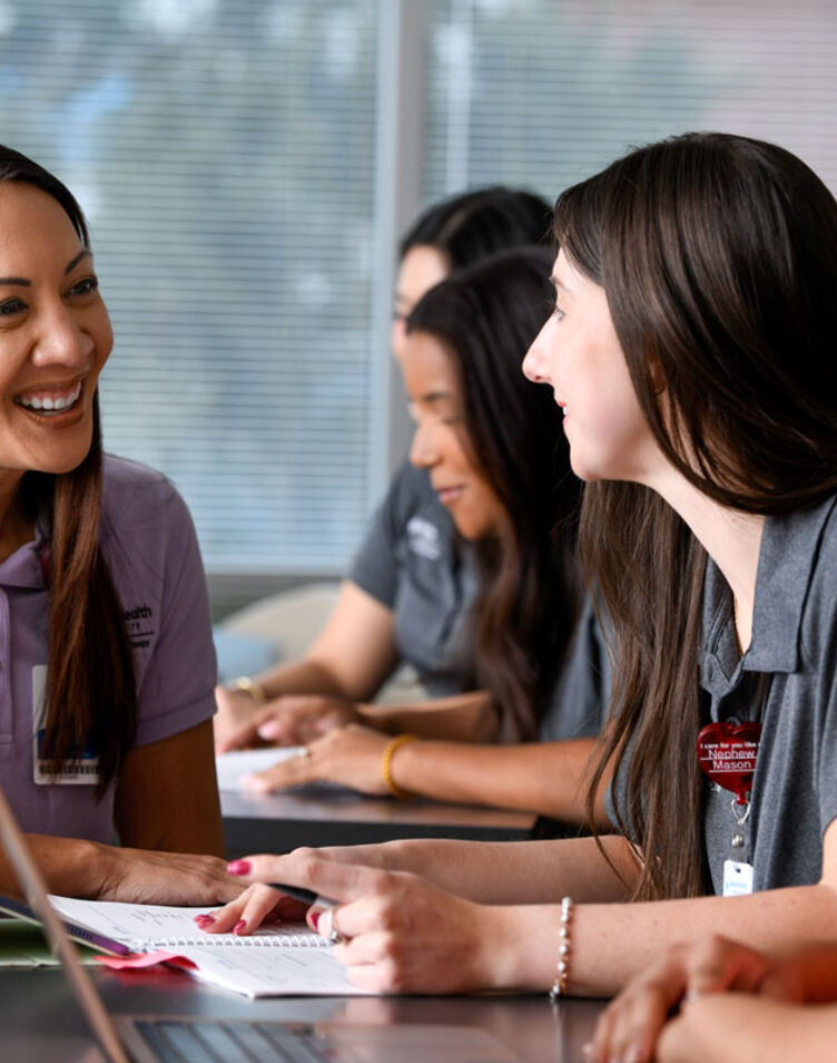 Students in a classroom smiling at faculty member