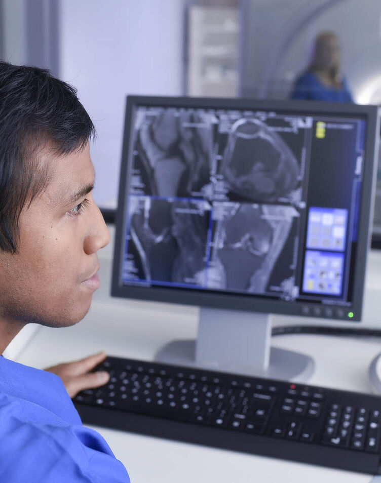 MRI Technician using a computer
