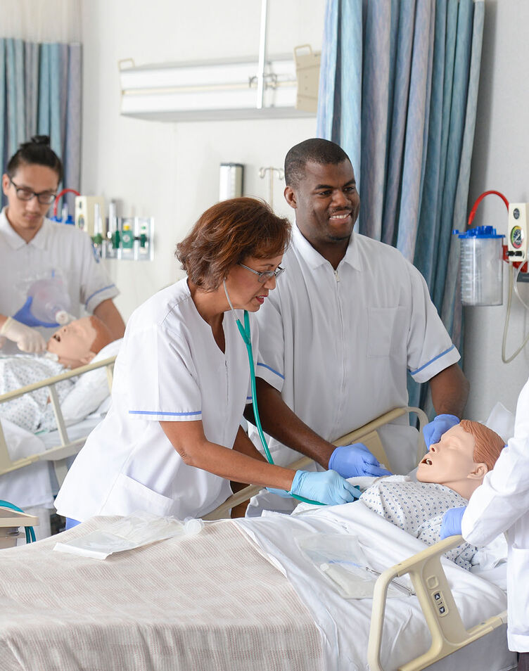 Nursing students practice their skills in the lab under faculty supervision