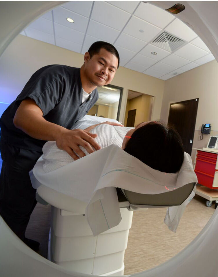 An imaging tech scans a patient